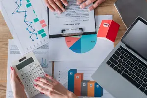 Financial planning with charts, calculator, and laptop