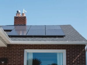 brown brick house with solar panels on roof