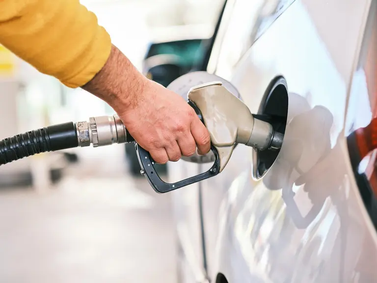 Hand refuelling car at petrol station pump