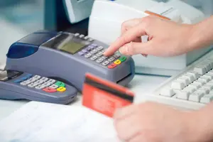 Person entering PIN on card payment terminal