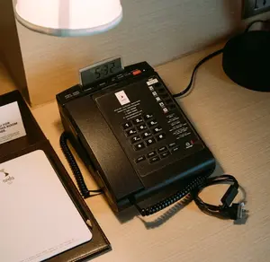 Cozy hotel room desk setup with lamp, telephone, and 5:32 PM clock.