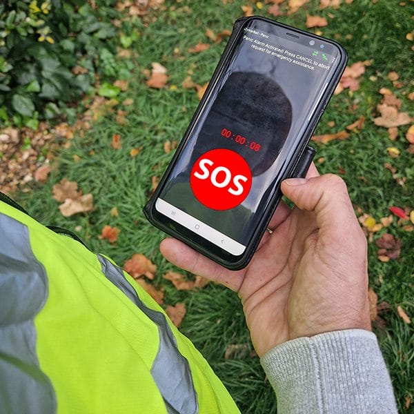 Crystal Ball lone worker app showing SOS emergency button on a smartphone held by a worker in a high-visibility vest