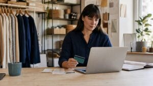 Small business owner managing expenses with software and a company card