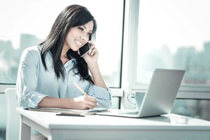 Woman on a business phone call taking notes